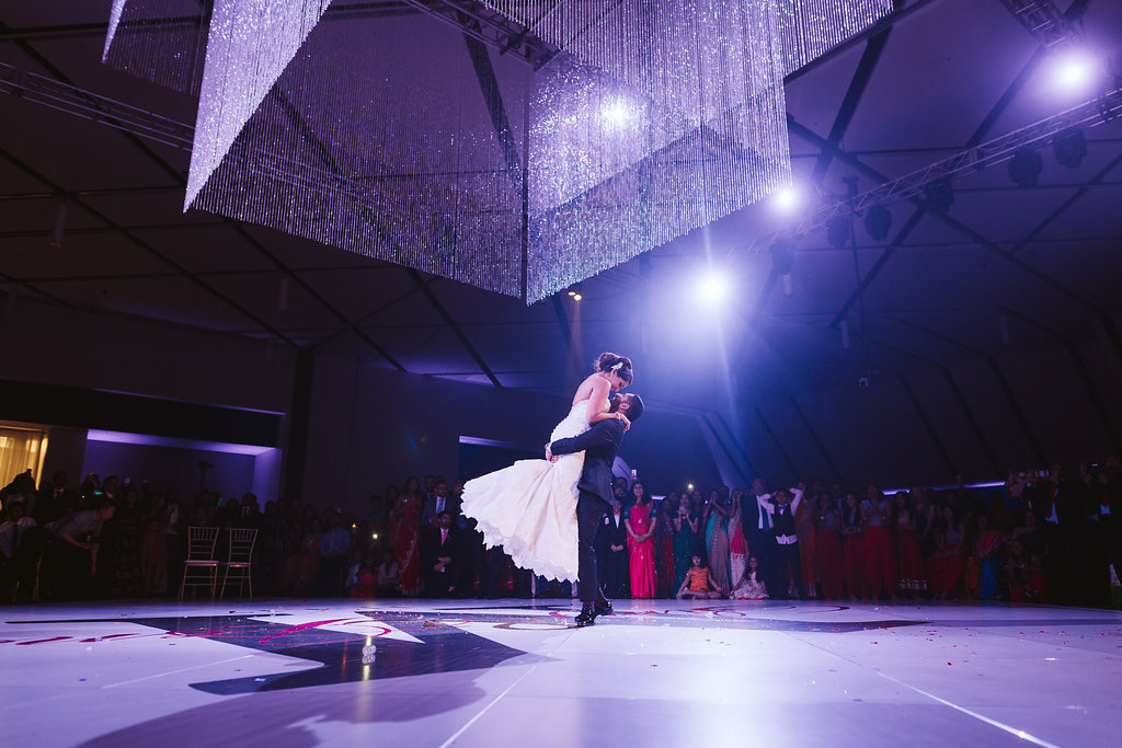 Couple having their first dance under bright dramatic lighting
